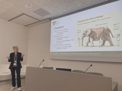 Photo of Christine Bauer (left-hand side) in front of a slide projection saying &lsquo;Context&rsquo;